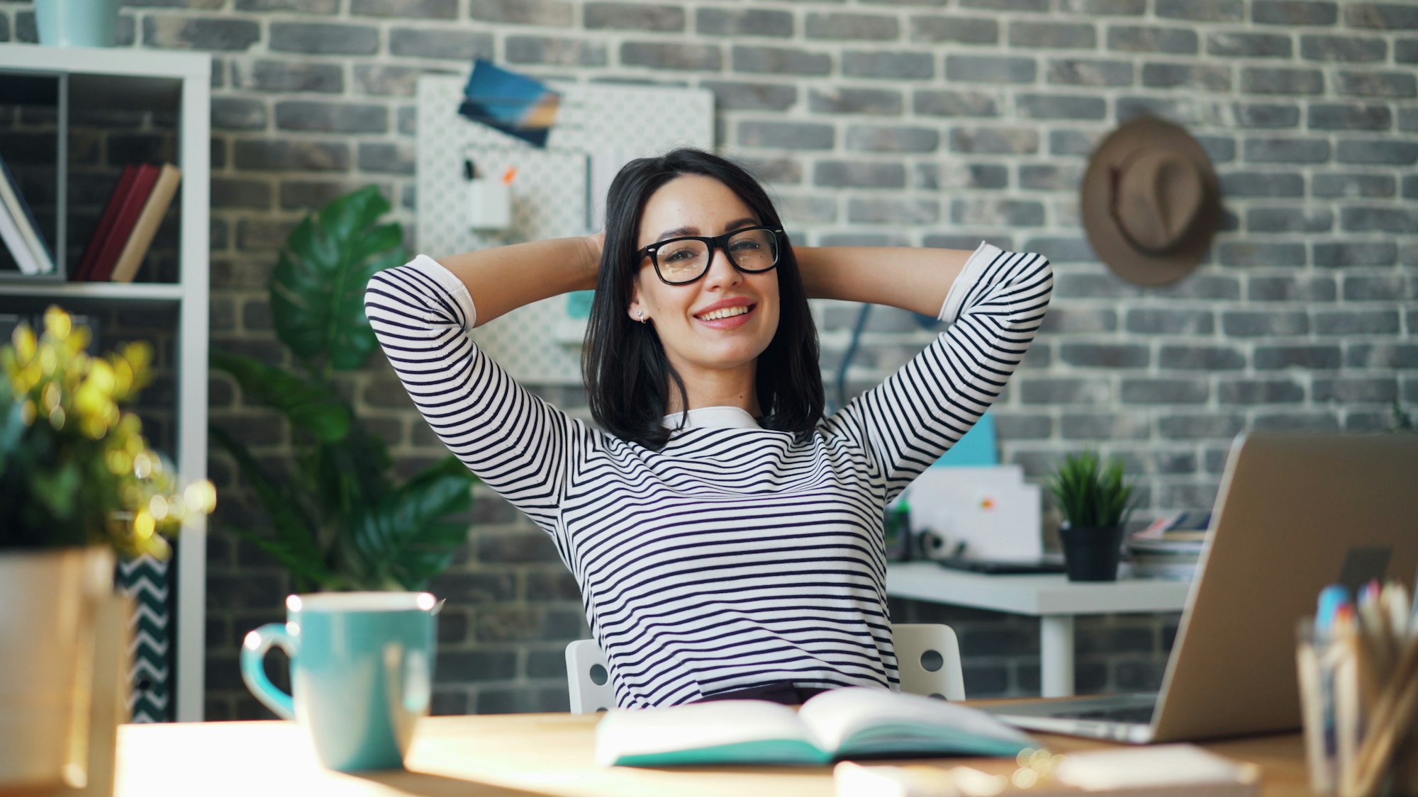 A relieved club or charity administrator sitting back from her laptop after automating recurring payment updates